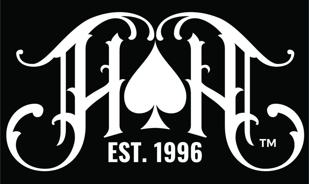 A stylized logo featuring the letters 'HN' with an ornate, gothic design. Between the letters is a spade symbol. Below the letters, the text 'EST. 1996' is displayed. The background is dark gray, and the design elements are white.