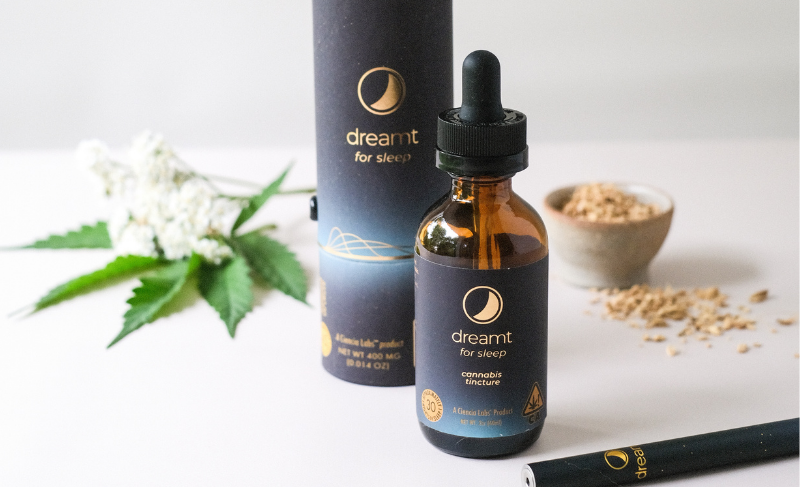 Dreamt for Sleep cannabis tincture bottle with dropper, packaging tube, and hemp leaves displayed on a white background.